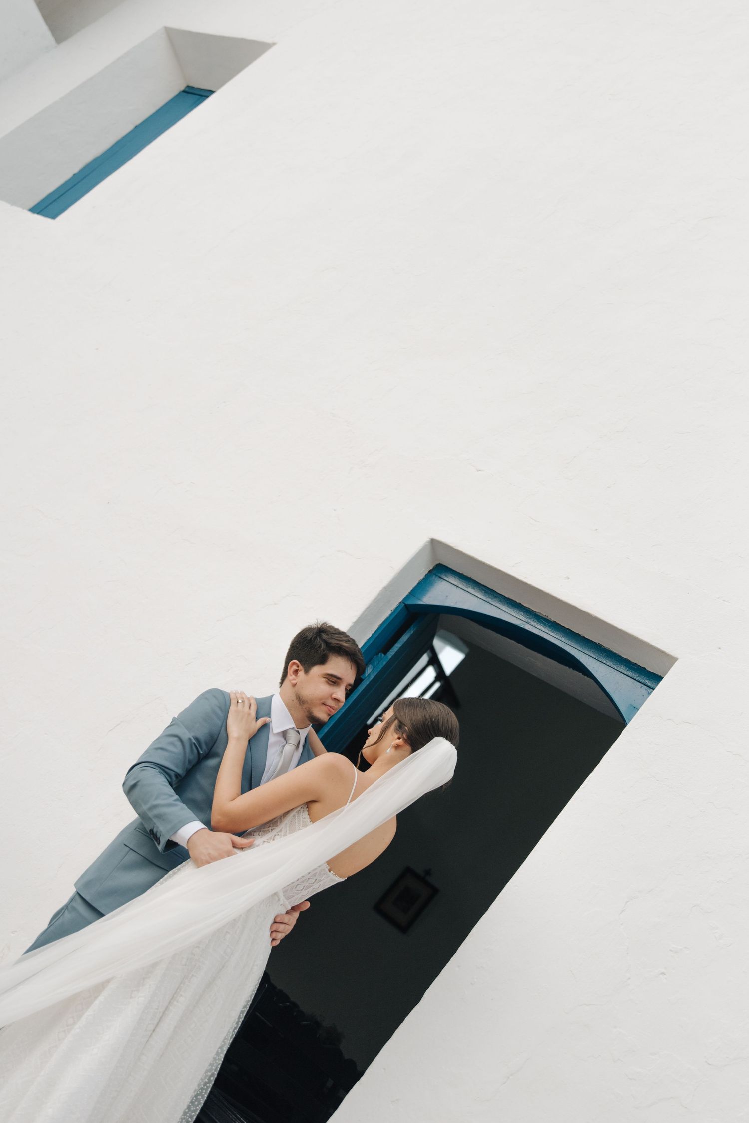 A romantic wedding pose captured through minimalist architectural framing.