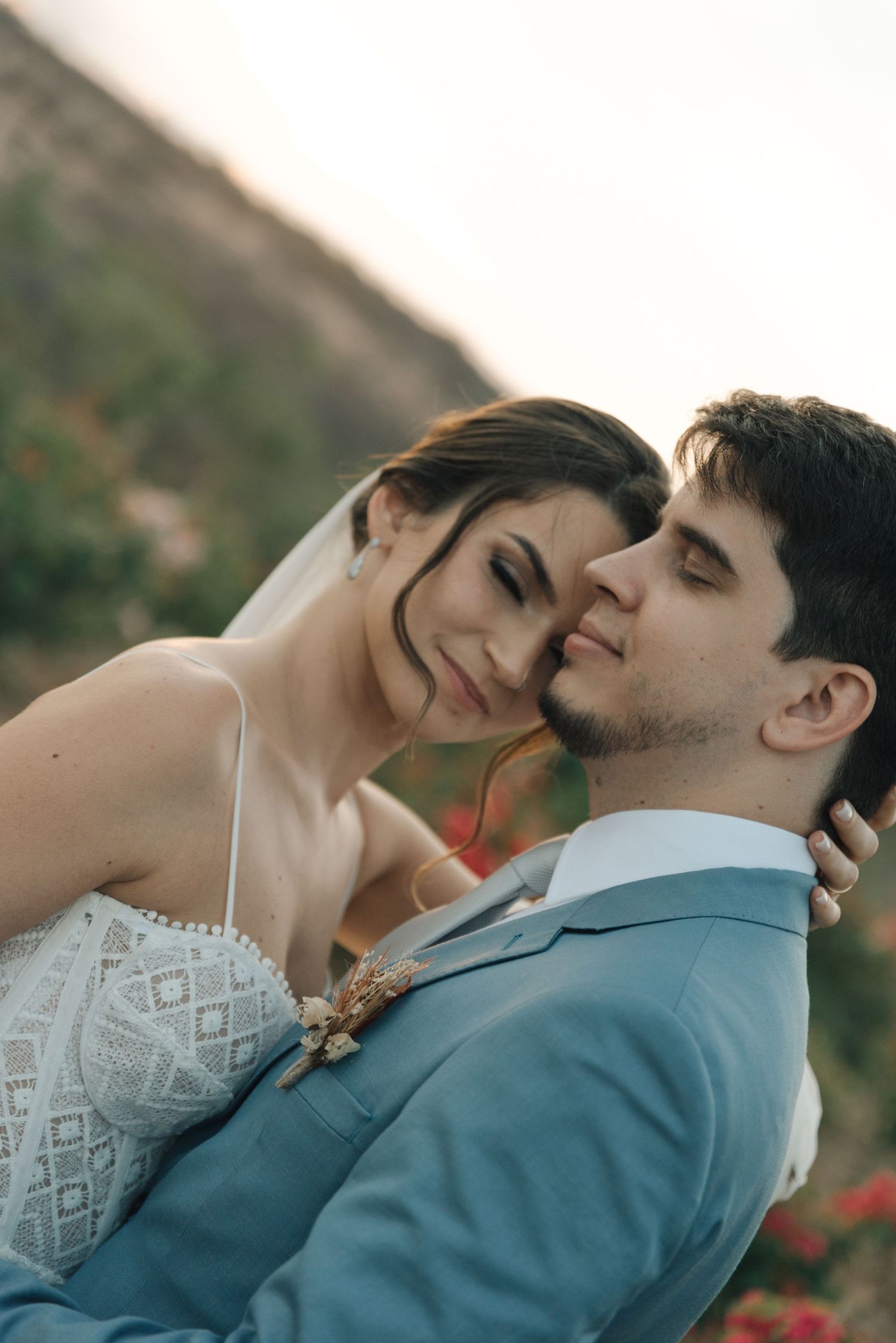 Intimate moment between newlyweds sharing joy and laughter in a desert setting.