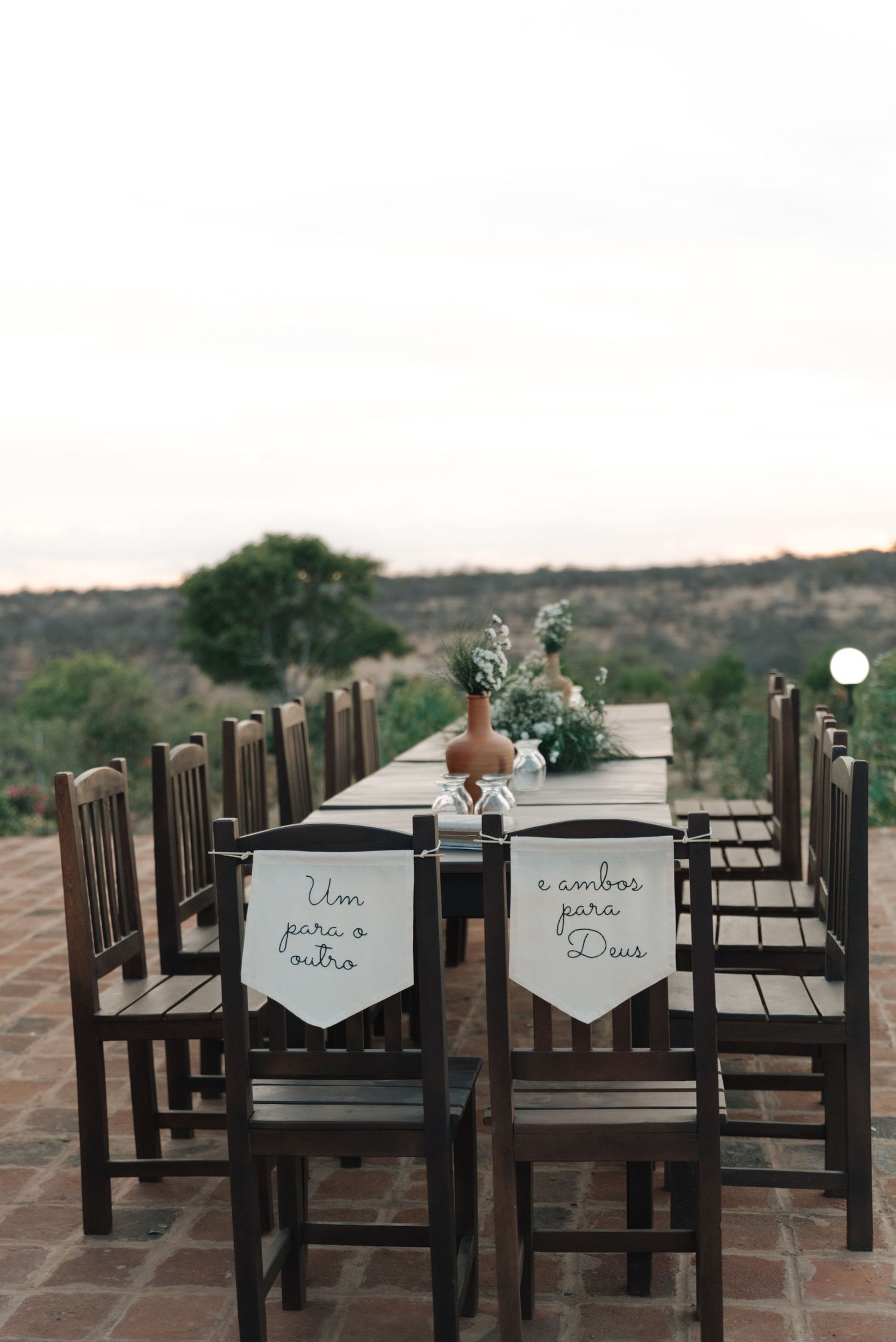Elegant wedding reception table with wooden chairs and personalized banner decorations.