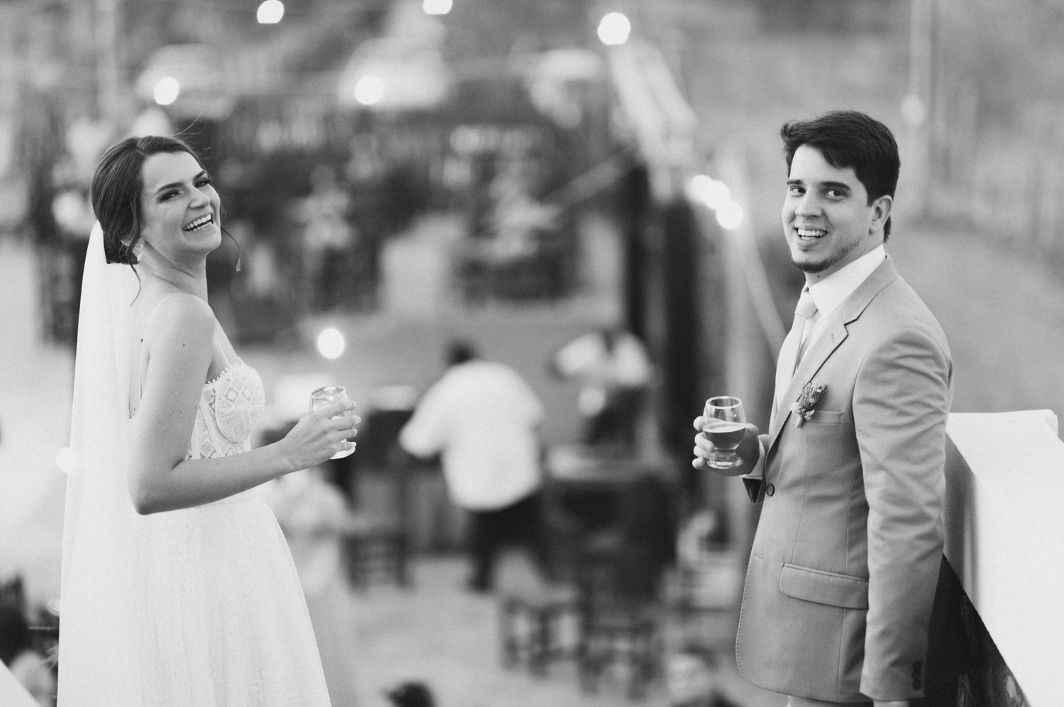 Wedding couple sharing joyful moment during outdoor reception celebration.
