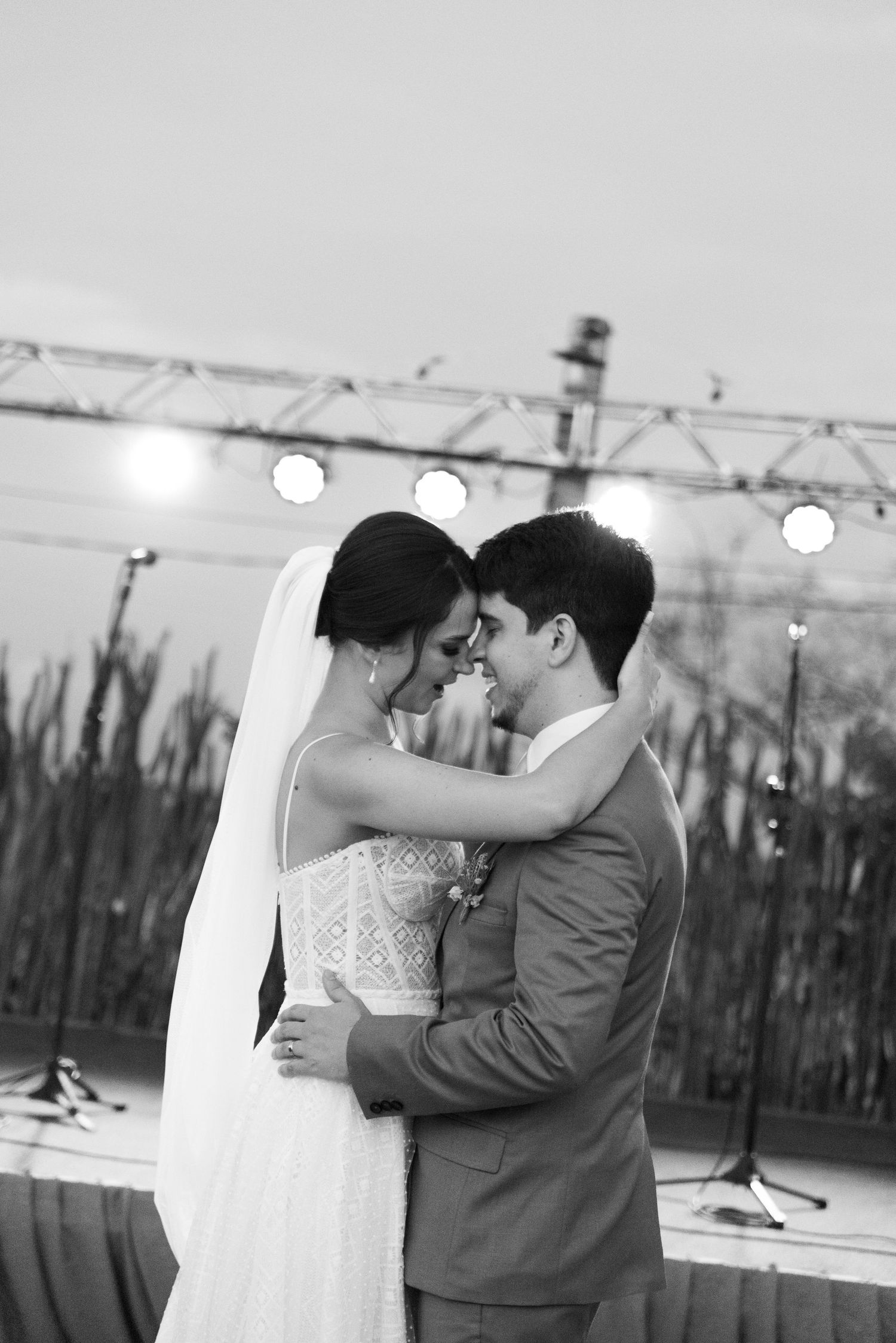 Intimate black and white portrait of a couple during their first dance at outdoor wedding venue.