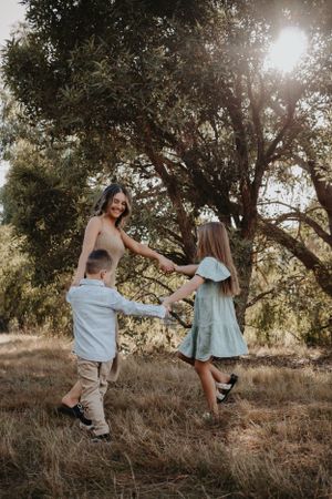 Mum and children holding hands dancing.