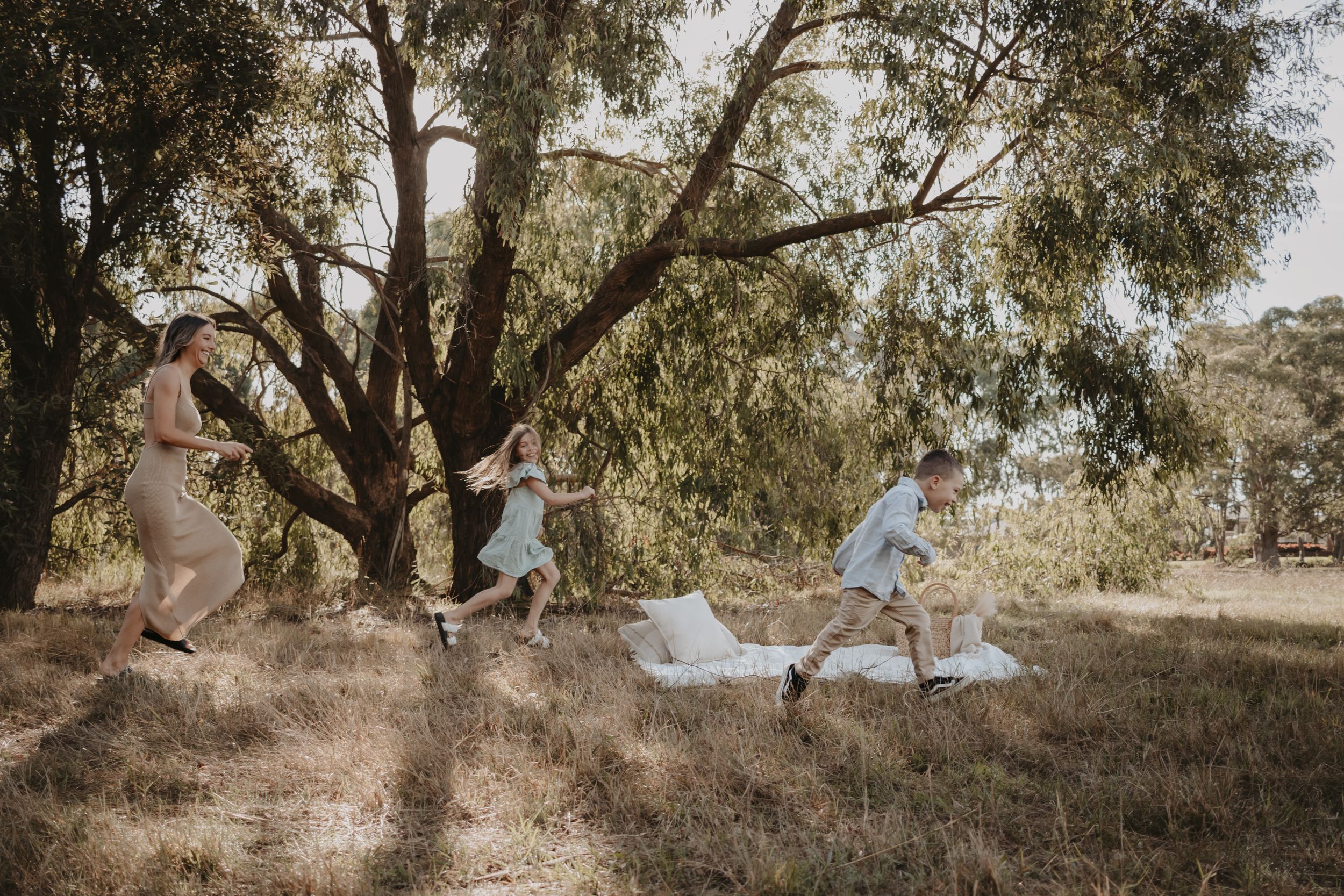 Children playfully running away from their mum.