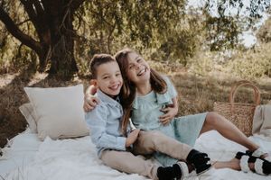 Brother and sister hugging and laughing with each other.