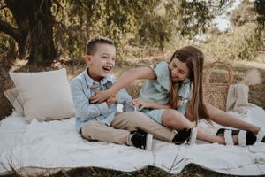 Brother and sister tickling each other.