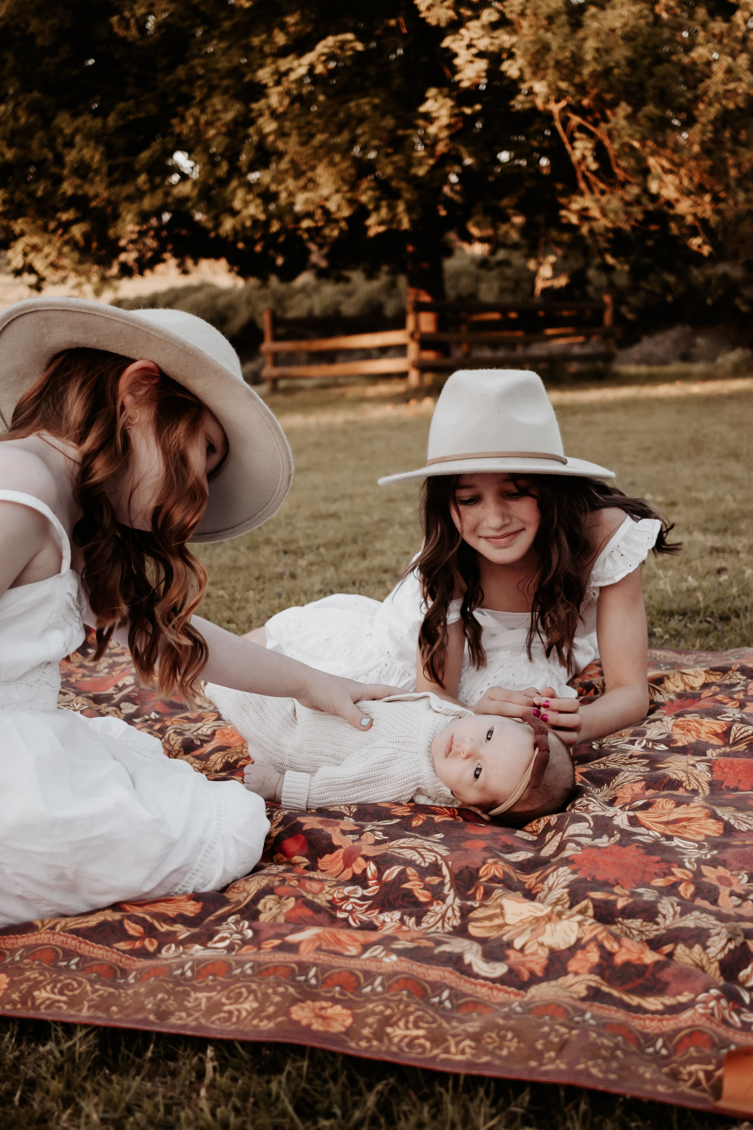 Two older girls playing with their newborn sister.
