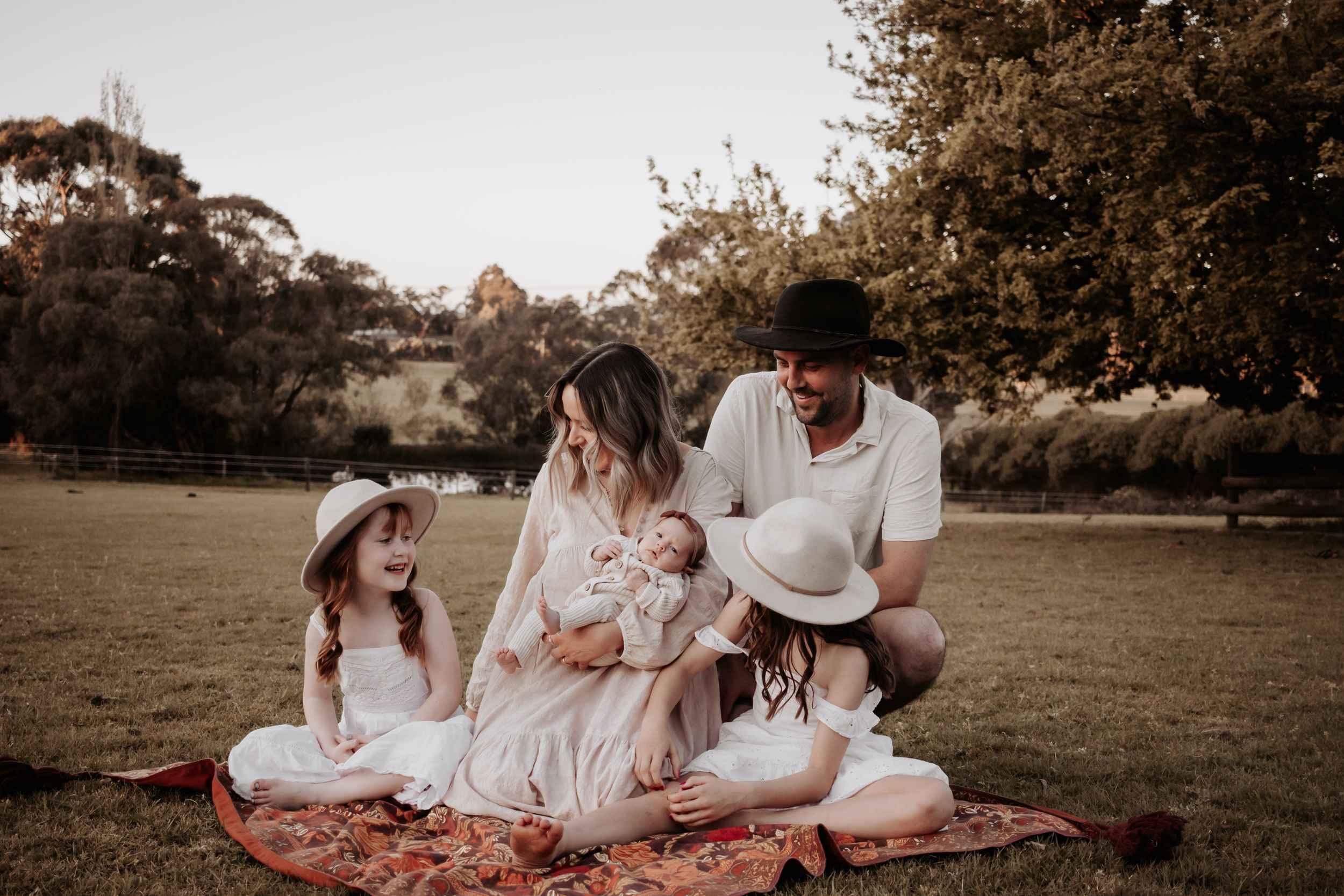 Family all looking at each other smiling.
