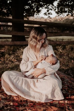 Mum holding newborn while looking down at her.