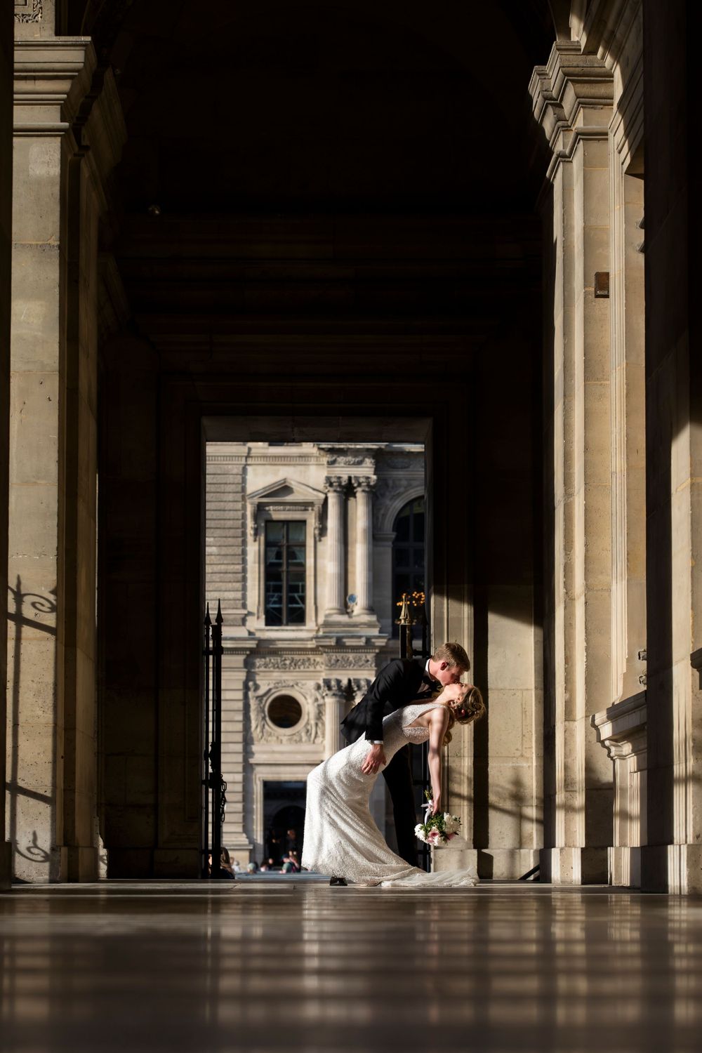 A beautiful couple dancing in the hallway of the Louvre Paris, wedding elopement photography captured by Julien LB Photography.