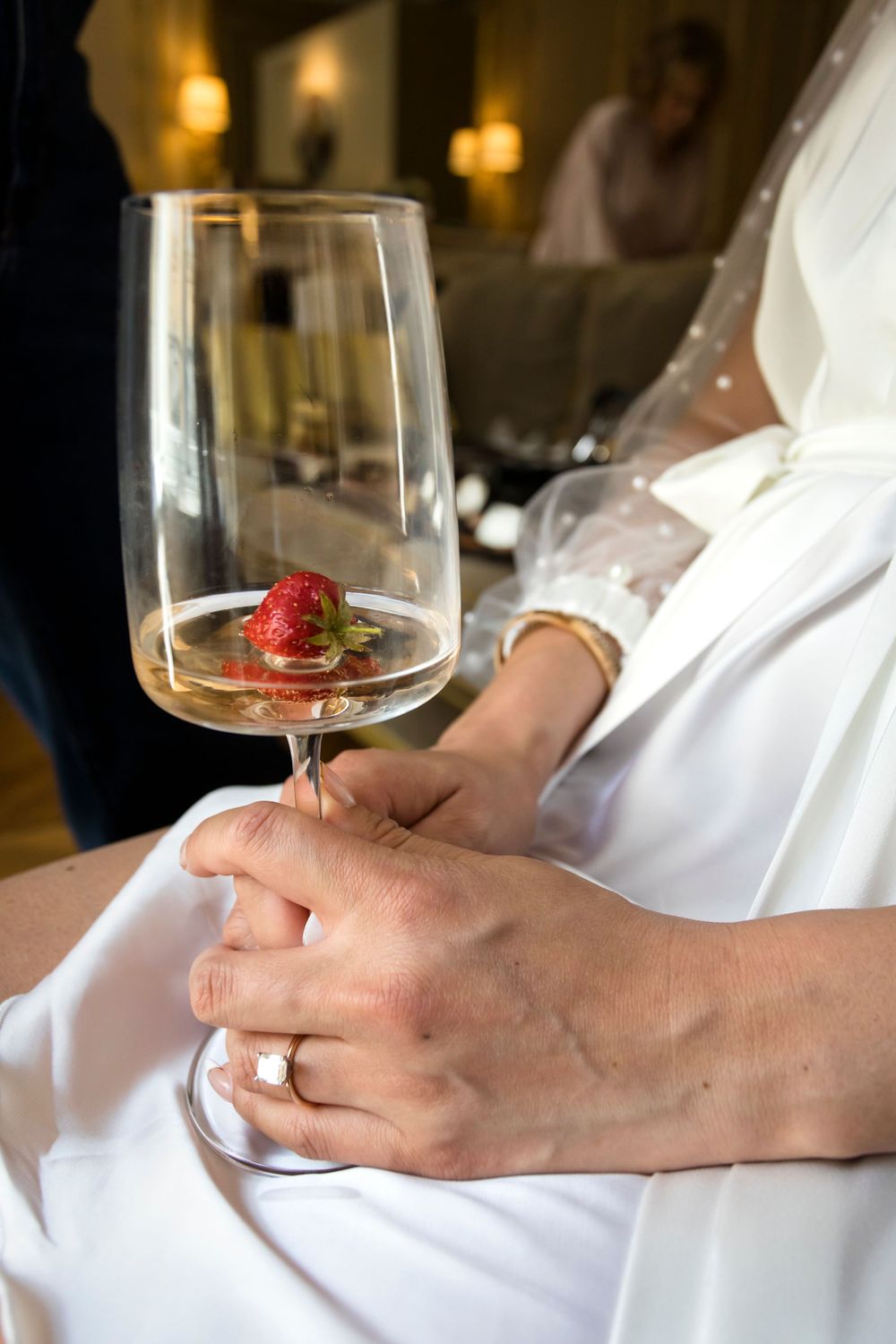 Photo by Julien Paris wedding Photography of a bride holding a flute of champagne with a strasberry in it