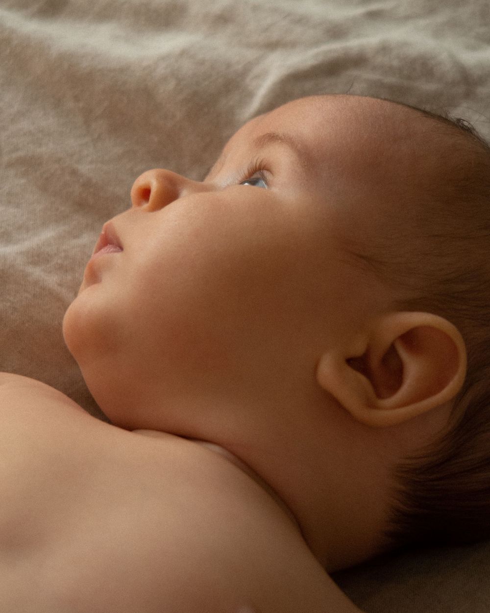 Profile view of sleeping baby in gentle natural light.
