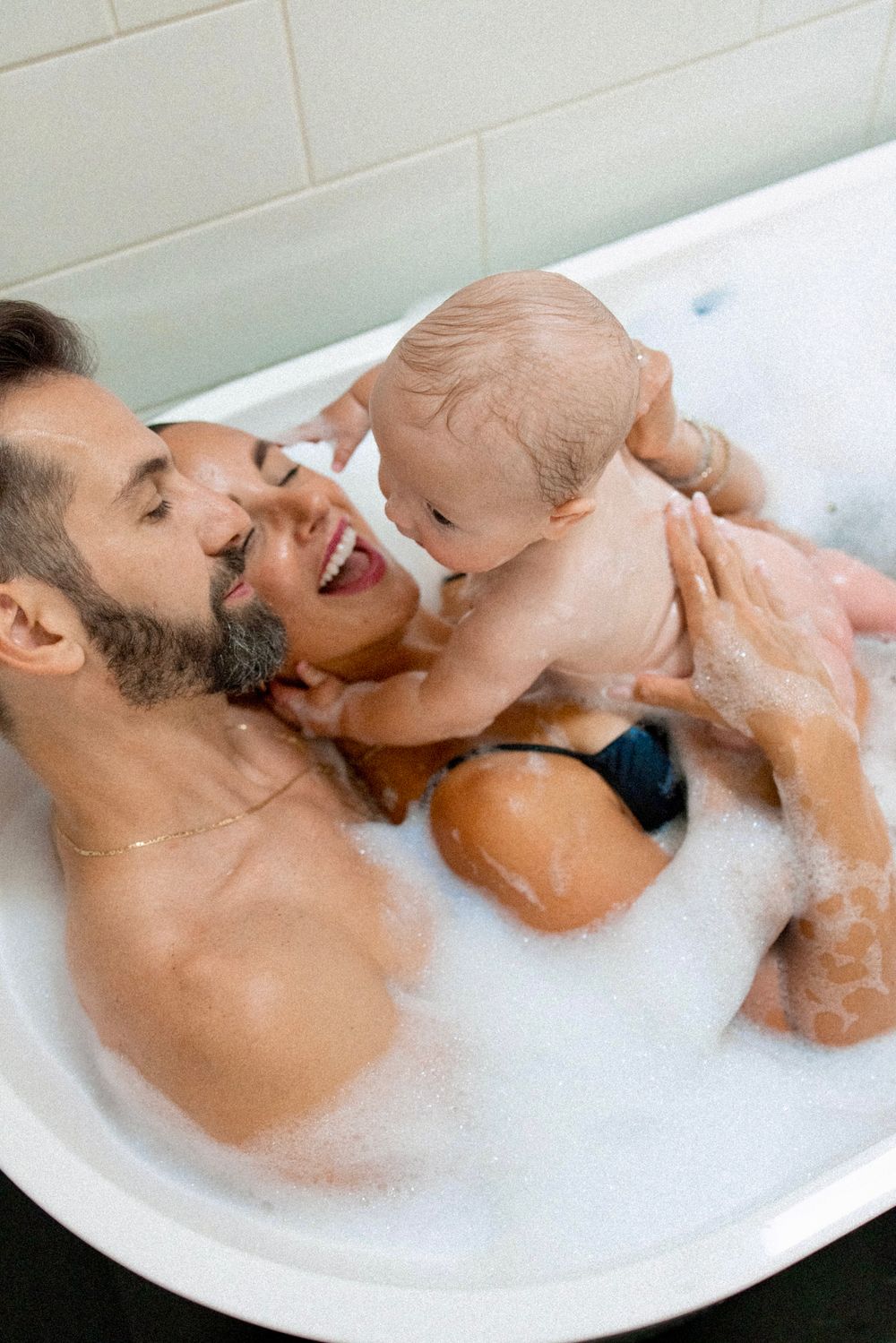 Playful bath time moments captured in a series of photos with bubbles and laughter.