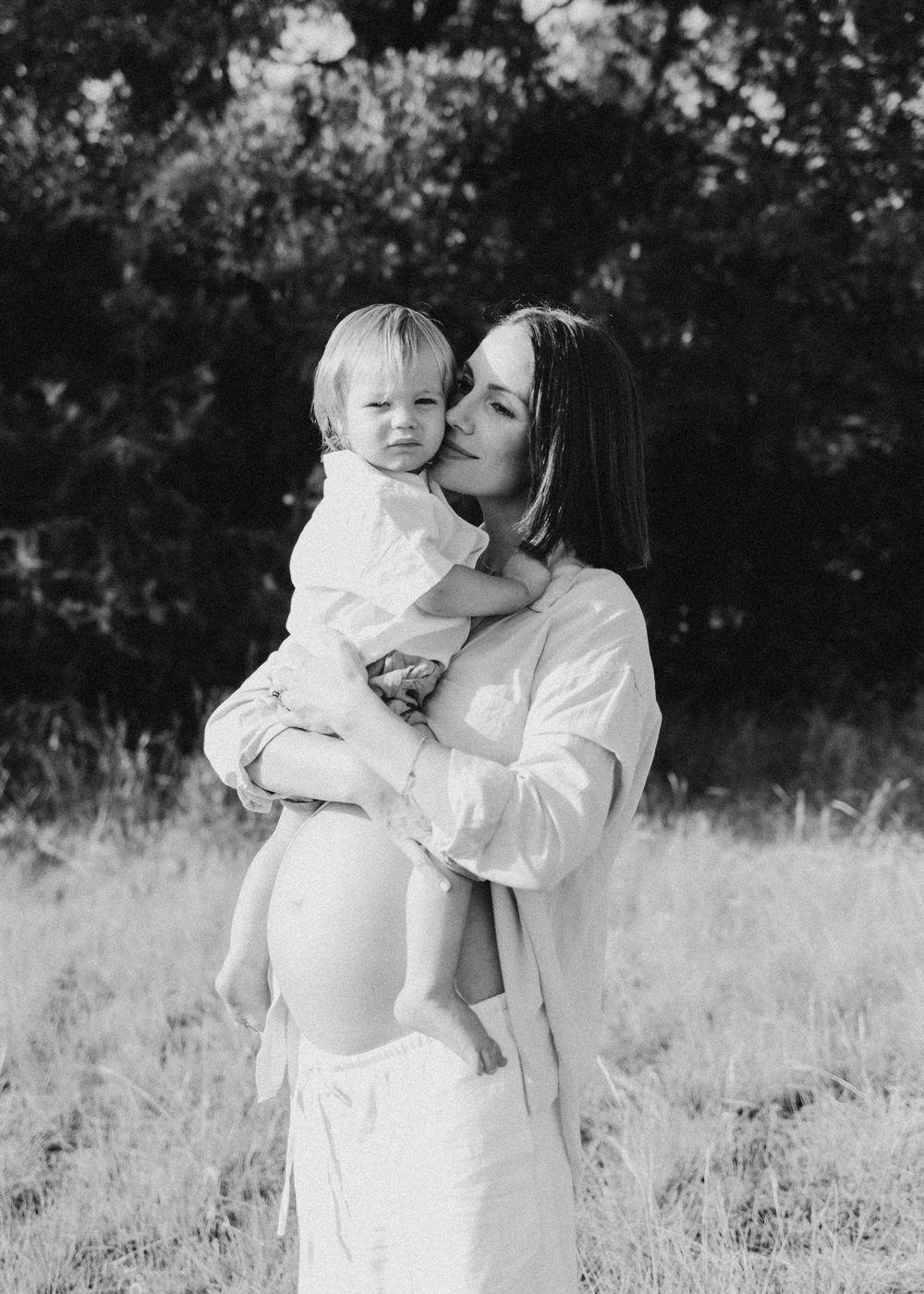 Sweet family moment captured in black and white photography outdoors.