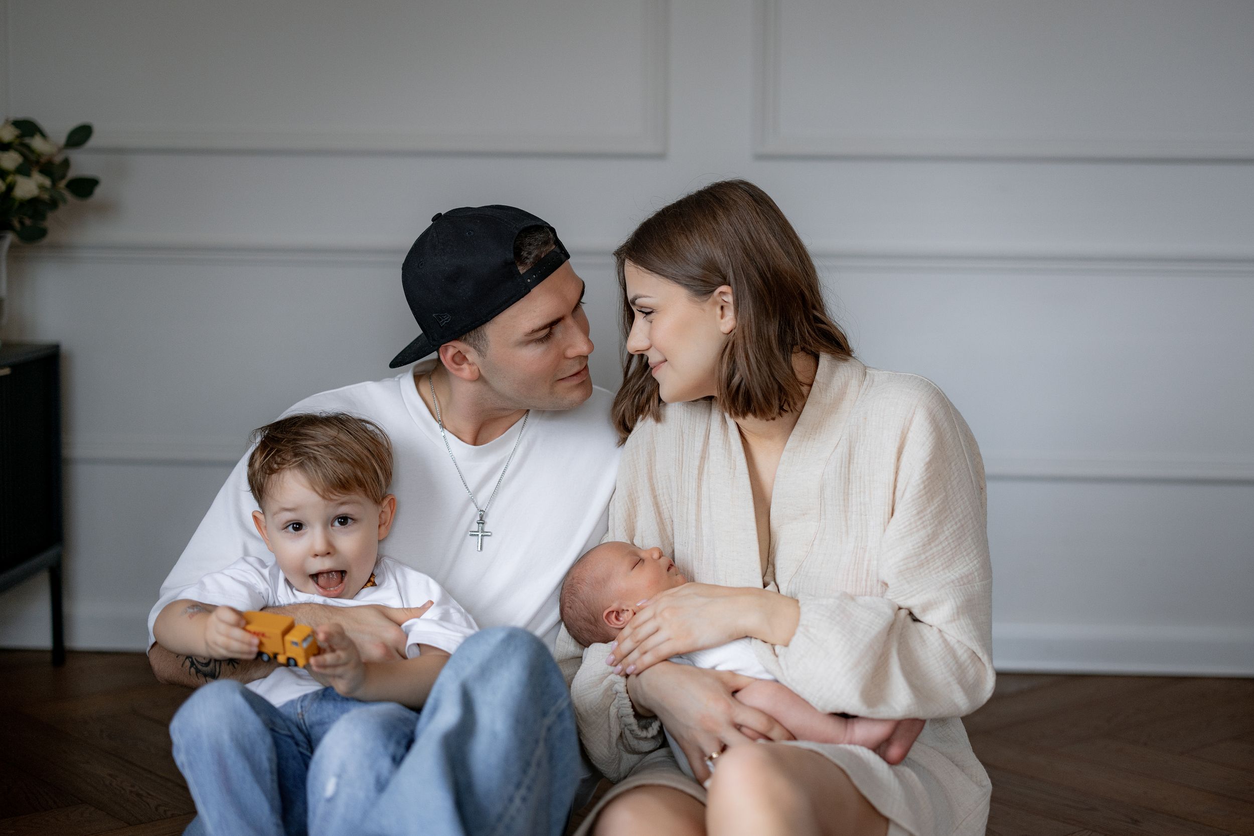 Young family sitting on floor bonding with their two children.