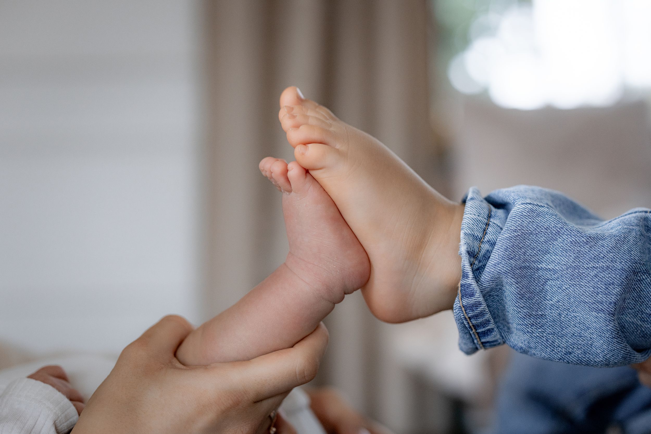 Close up of parent gently holding baby's foot in tender moment.