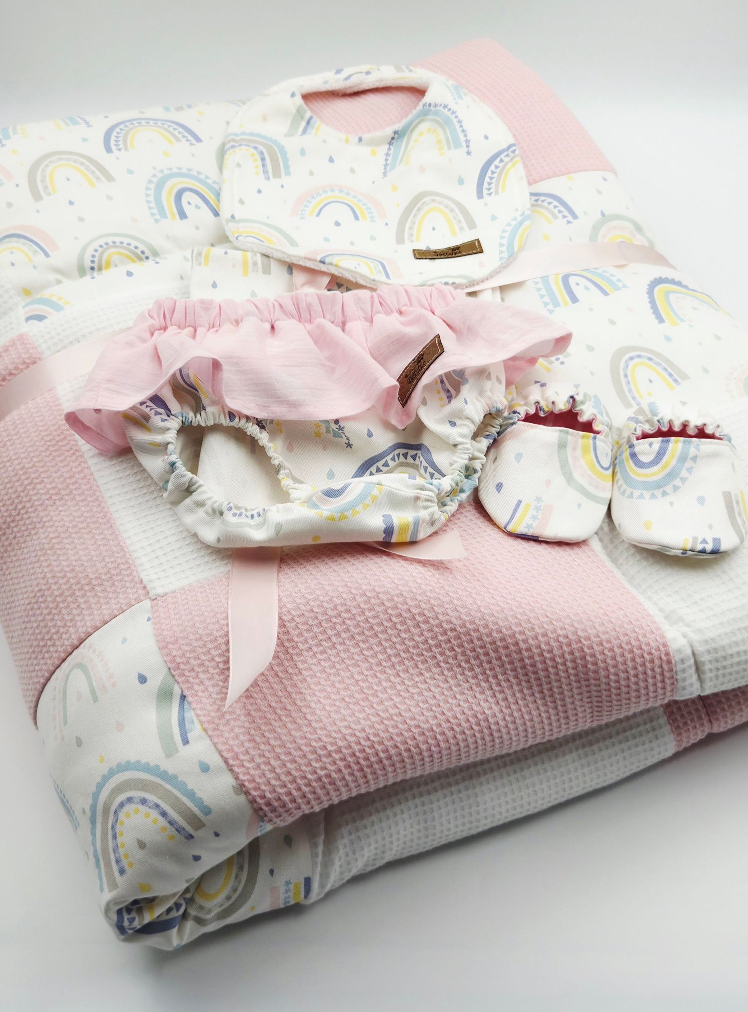 Pink and white baby accessories set with rainbow pattern fabric and matching booties.