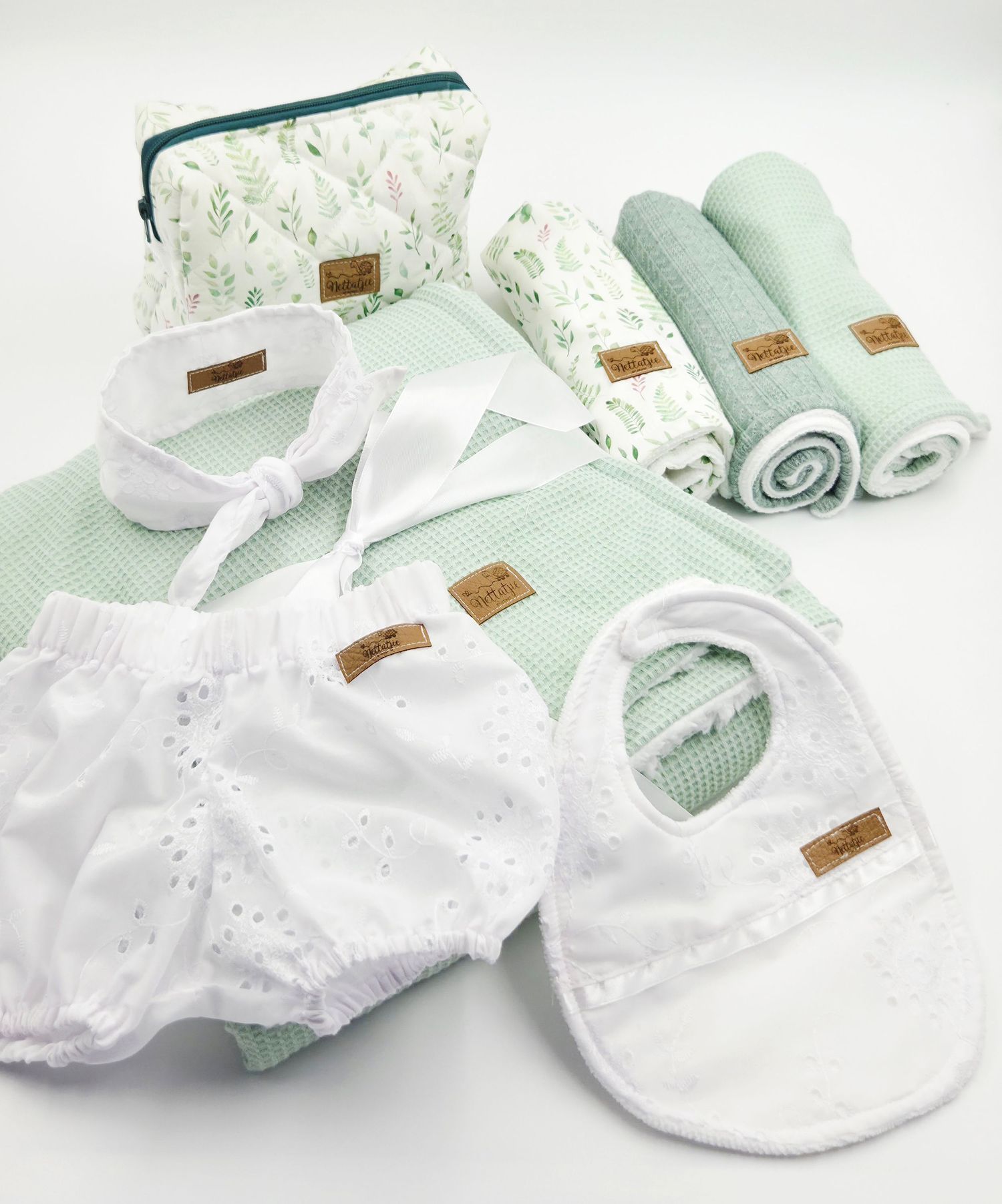 Mint floral baby accessories including bibs, blankets and a matching toiletry bag.