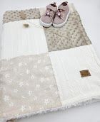 Soft baby blanket patchwork quilt in beige and white with floral print, paired with pink infant sneakers.