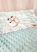 Soft mint minky dot baby blanket with pink floral print and pink baby shoes on top.