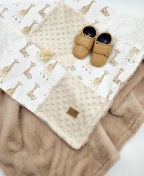 Baby blanket with giraffe print and tan minky backing, paired with caramel leather baby moccasins.