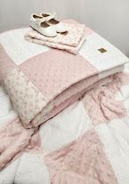 Pink and white patchwork baby quilt set with minky dots, floral accents, and matching pillow, displayed with white baby shoes.