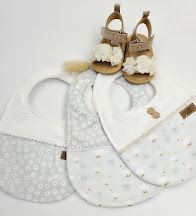 Three white baby bibs with delicate patterns displayed with tan leather infant sandals with ruffles on white background.