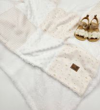 Soft cream waffle knit baby blanket with matching dotted hat and tan sandals on white background.