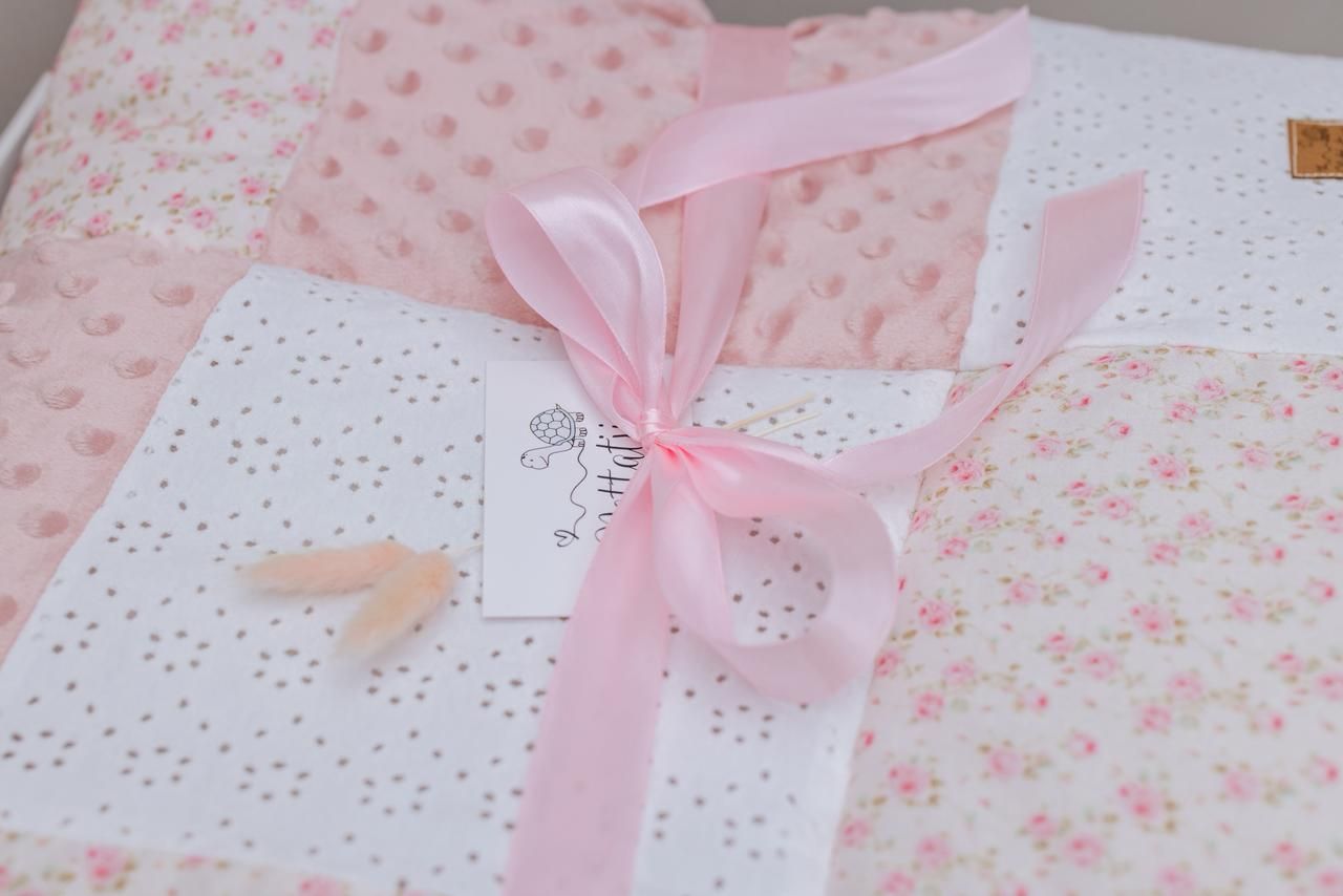 Pink gift wrapping with delicate ribbon bows and floral pattern details.