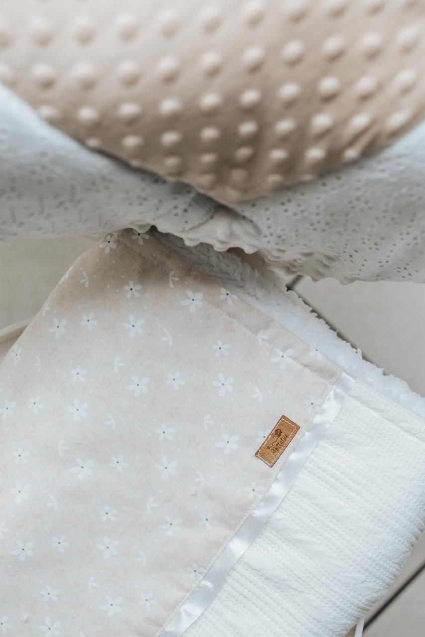 Close-up of white textured fabric with small tag and dotted pattern in soft, neutral tones.