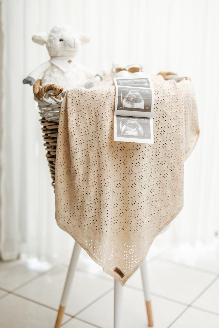 Delicate cream-colored lace tablecloth draped elegantly over a table in a bright white room.