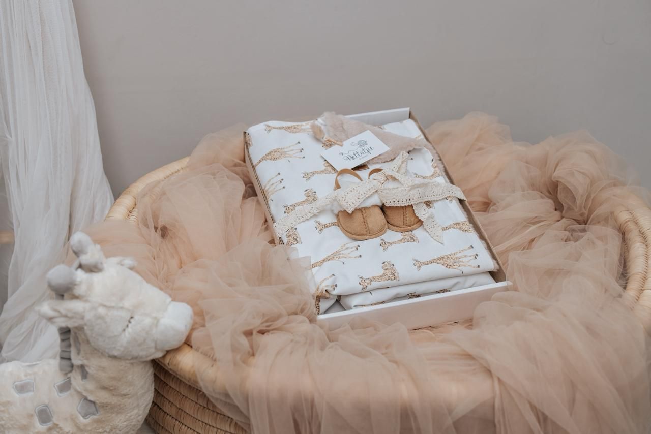 Soft beige baby blanket with delicate patterns laid out on light background.