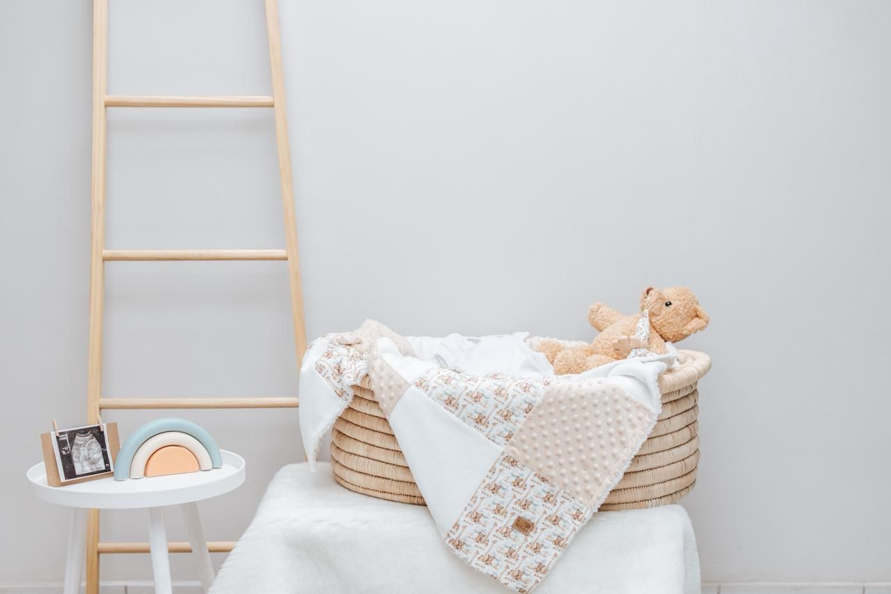 Soft neutral nursery decor with white ladder and plush toys arranged on shelving.