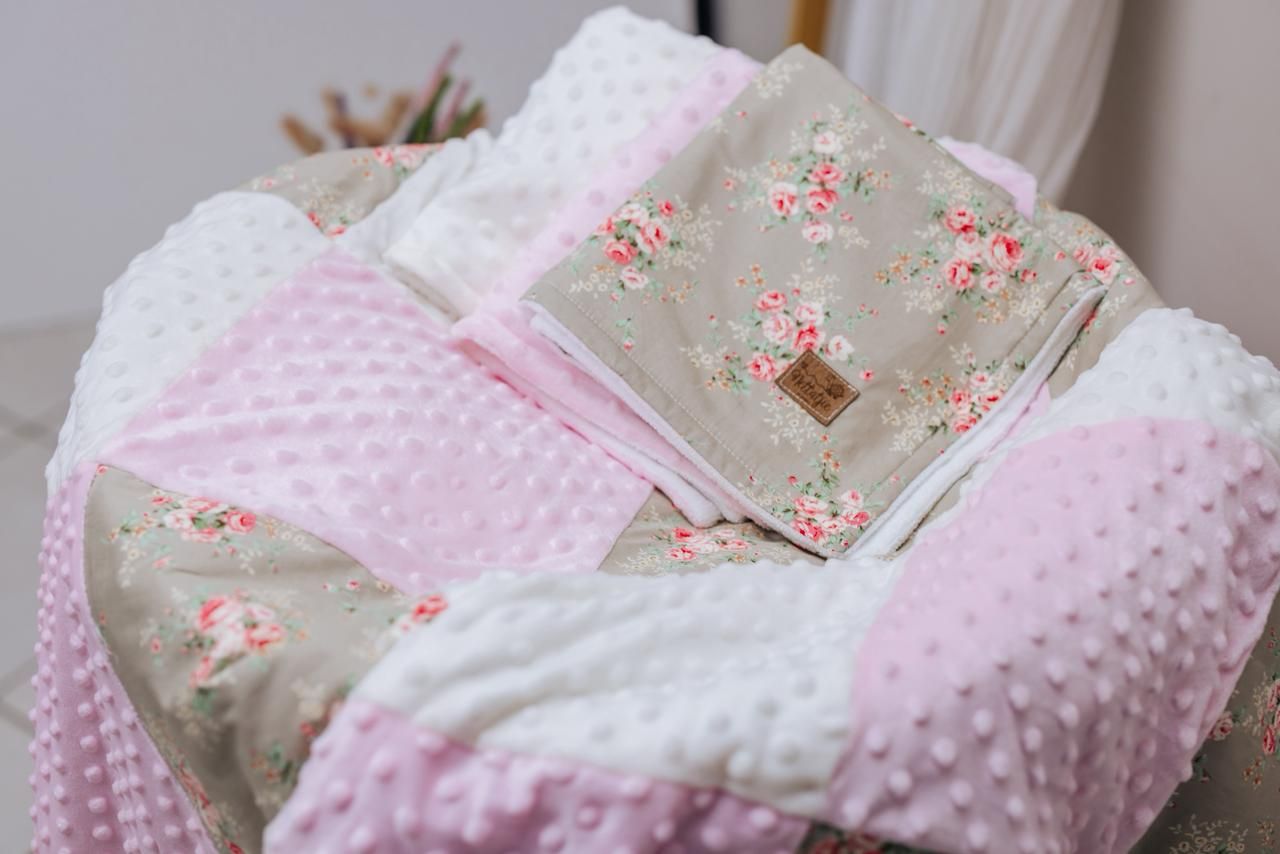 Pink and beige minky baby blankets with delicate floral patterns layered together.