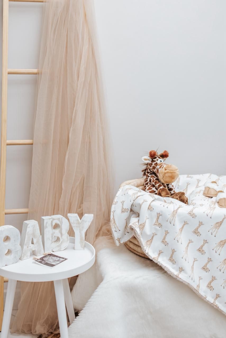 White decorative letters spelling 'BABY' displayed with stuffed animals and neutral decor.