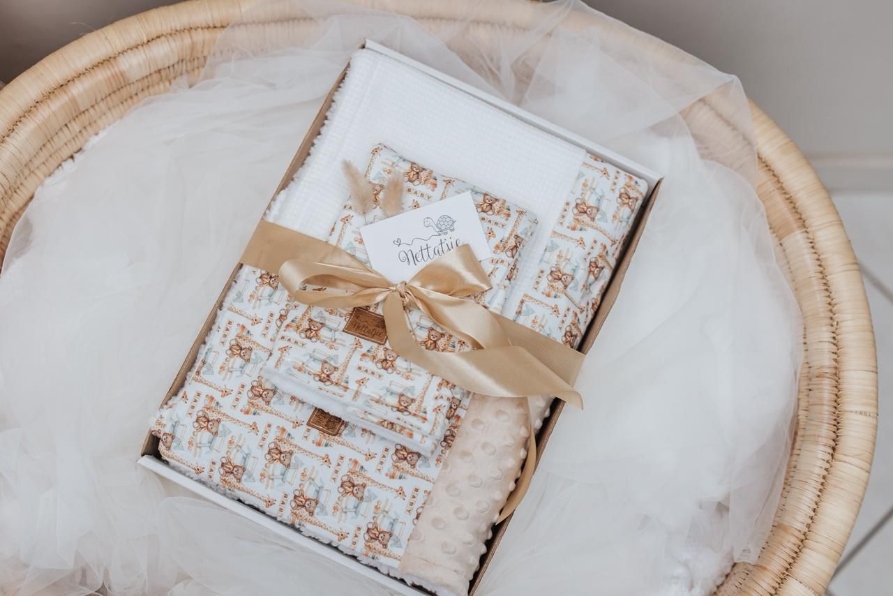 Beige and white gift wrapping supplies arranged artistically on wooden surface.