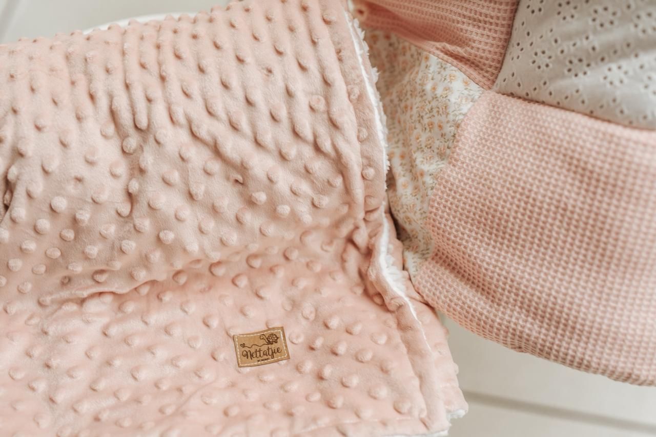 Pink and white textured fabric swatches arranged in a collage pattern showing various quilted and dotted designs.