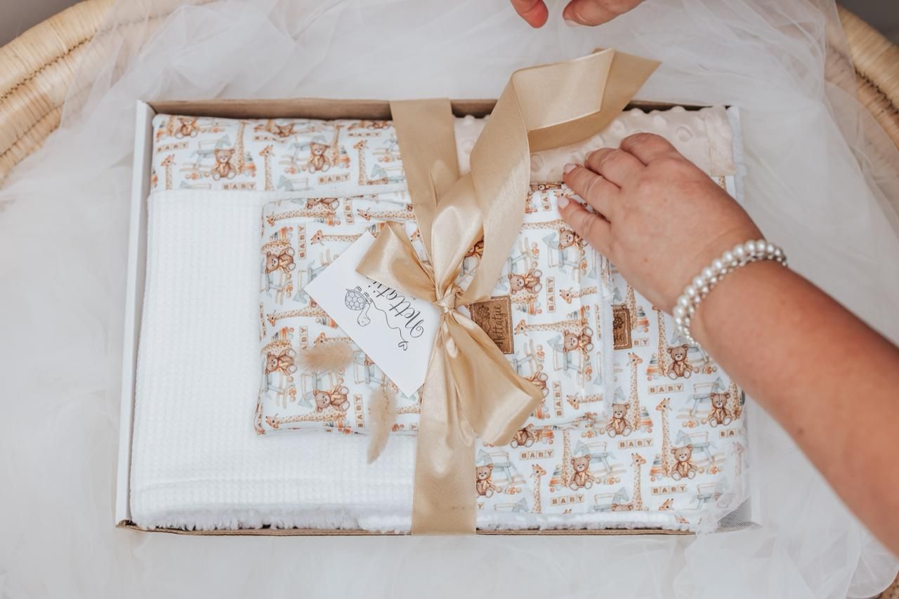 Hands wrapping a gift with brown and white patterned paper.