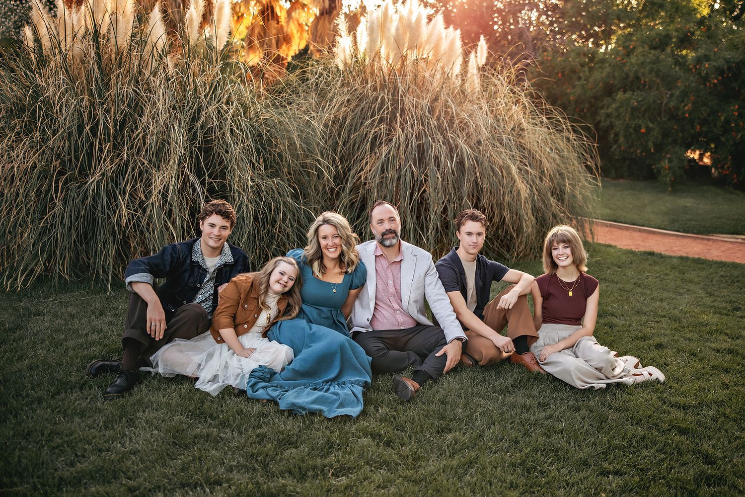 Family posing together against stunning red rock formations in the desert at sunset.