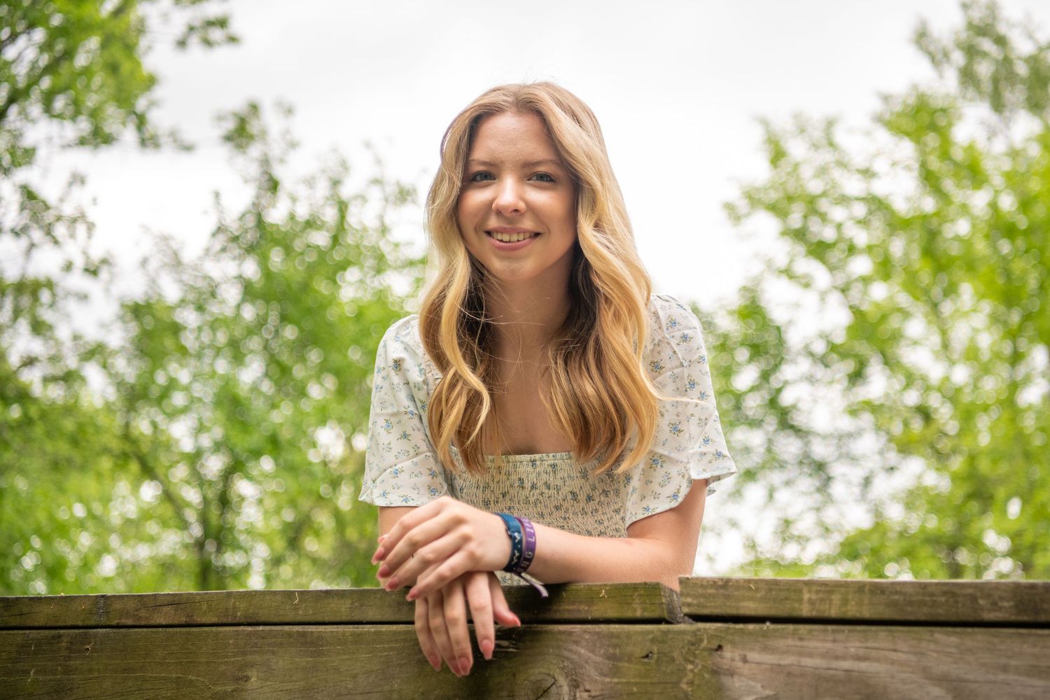 A series of outdoor portraits featuring someone in a white floral dress against greenery.