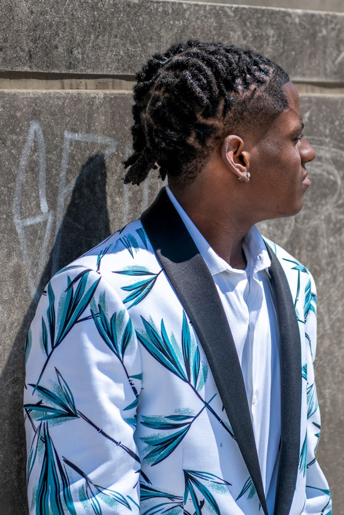 Side profile view of someone wearing a distinctive white blazer with blue leaf patterns.
