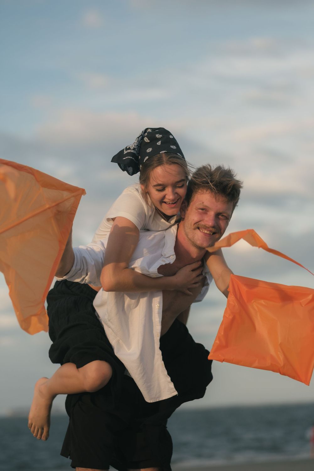 Engaged couple embracing on Folly Beach at sunset during a Charleston couples photography session.
