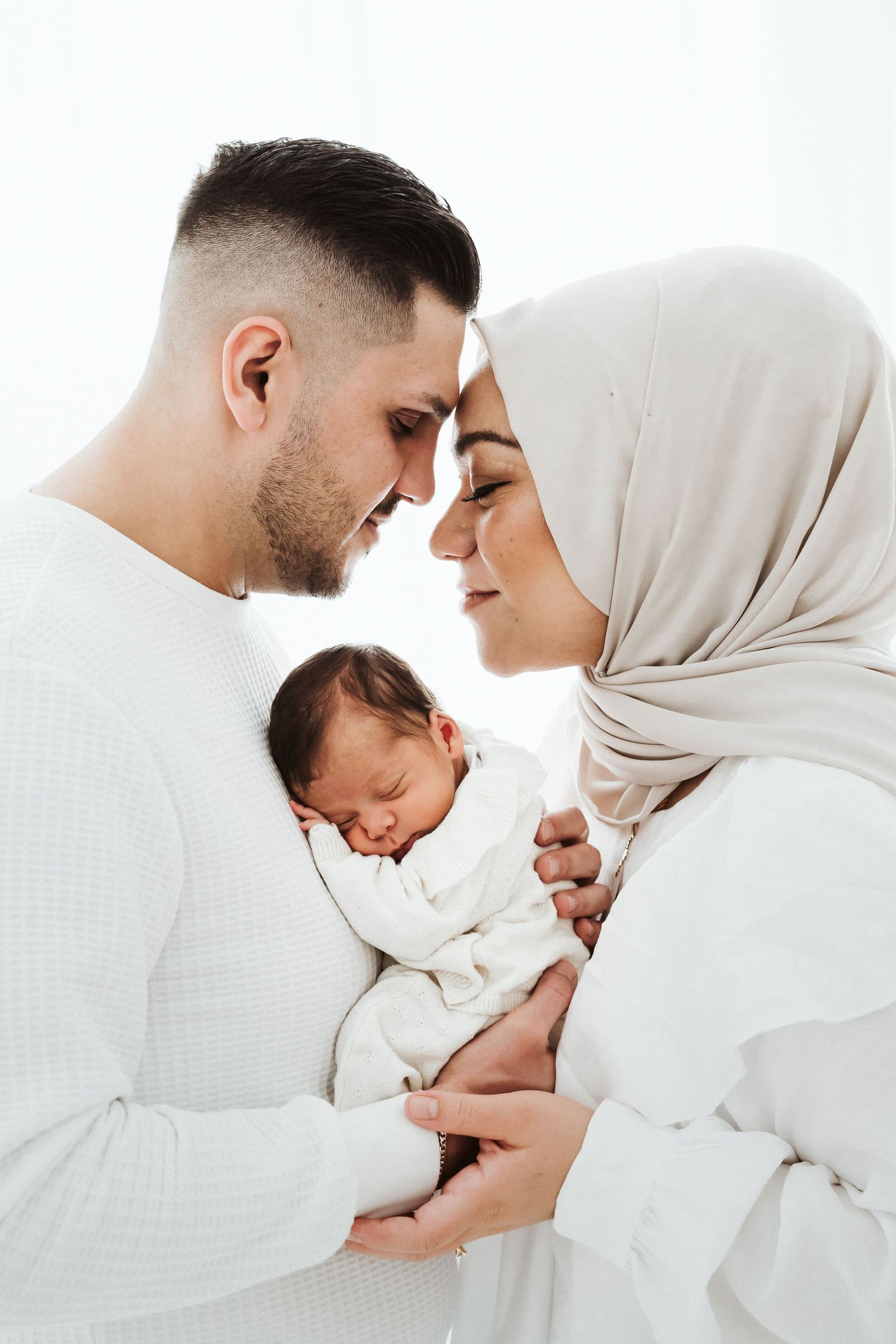 Modern family portrait session featuring traditional white hijab and coordinated outfits.