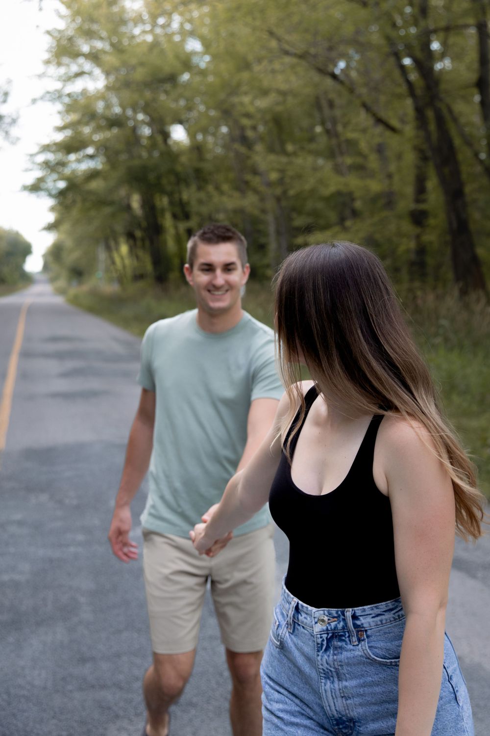 A casual stroll down a scenic tree-lined road on a sunny day.