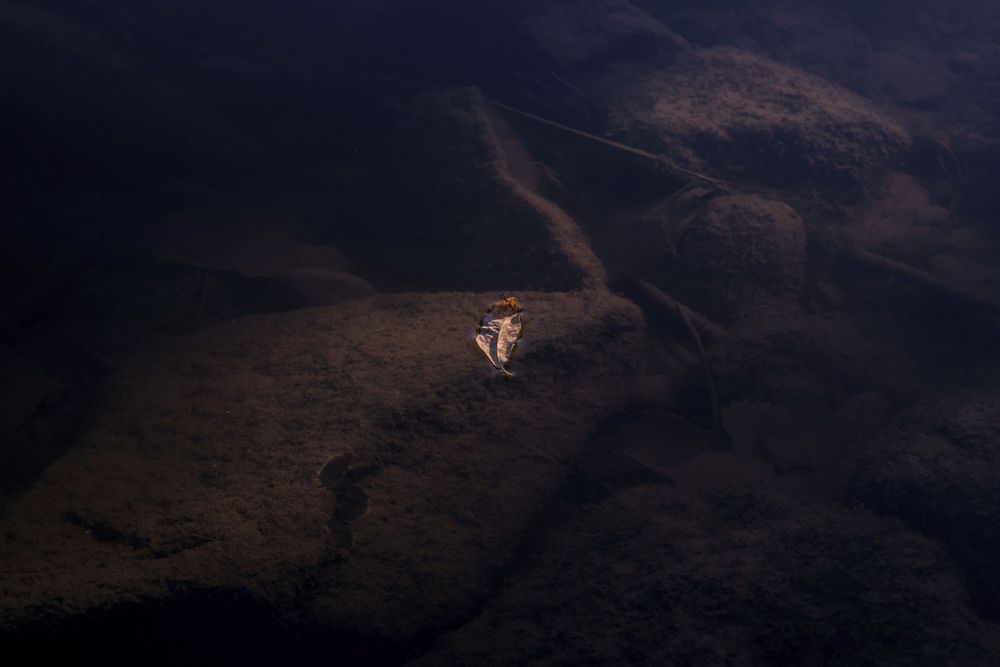 Single glowing light illuminates dark mountainside at night.