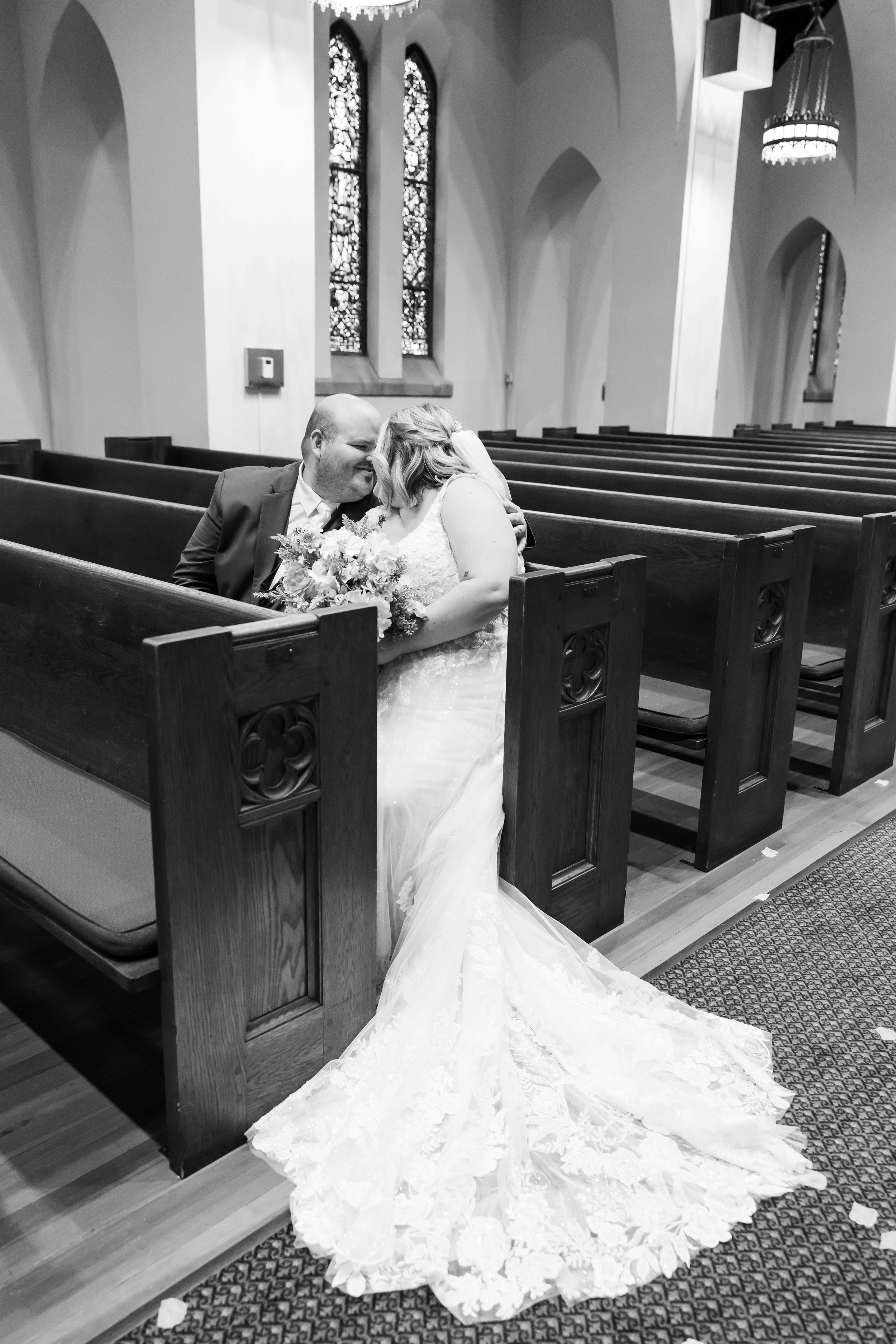 bride and groom sharing a kiss in church pew in Springfield Illinois