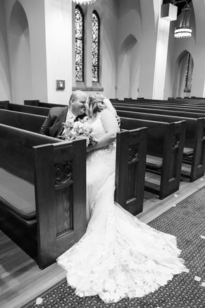 bride and groom sharing a kiss in church pew in Springfield Illinois