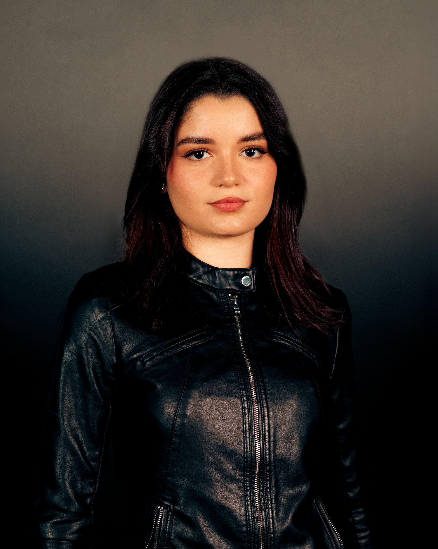 Artistic portrait series featuring dramatic lighting and black leather jacket against dark background.