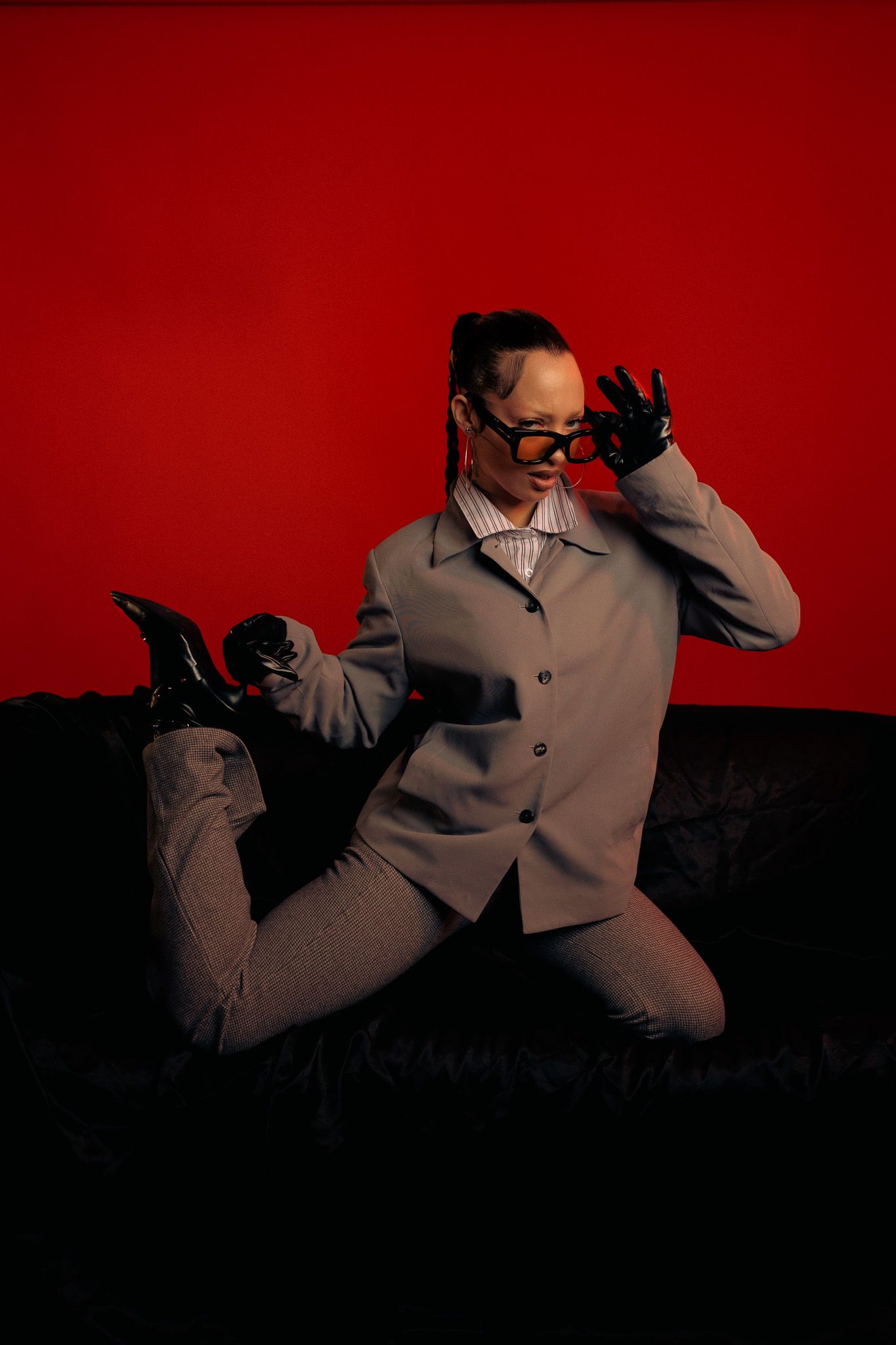 Silhouetted figure in a suit jacket poses dramatically against a deep red background in a sequence of motion shots.