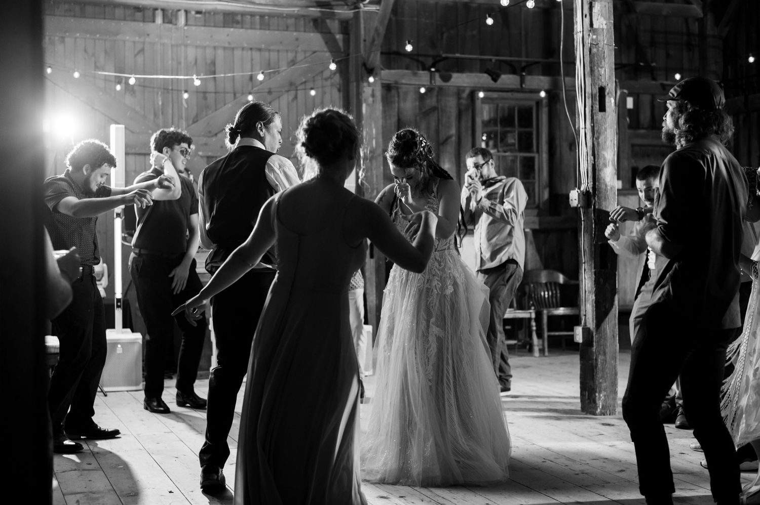 Black and white photograph of wedding reception dance floor celebration.