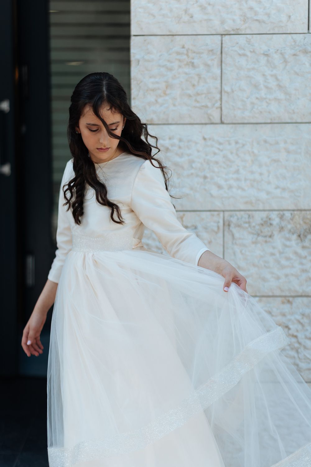 A figure in a flowing white dress twirls against a stone wall backdrop, creating an elegant spinning motion effect.